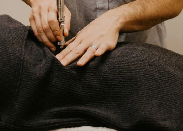 Chiropractor performing spinal adjustment on a patient’s lower back to relieve sciatic nerve pain.