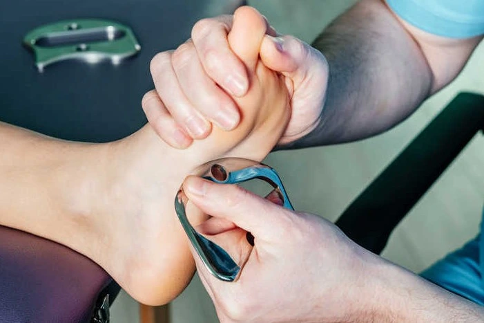 Plantar fasciitis treatment using a scraping tool on the foot
