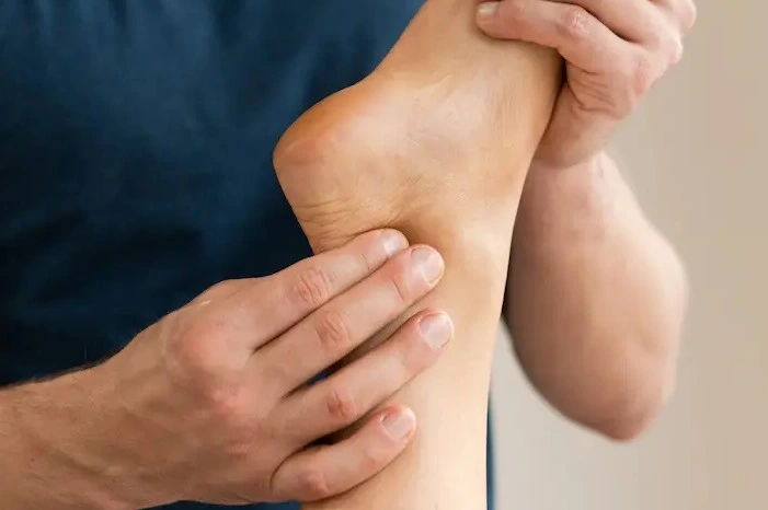 Person applying pressure to the heel for plantar fasciitis pain relief