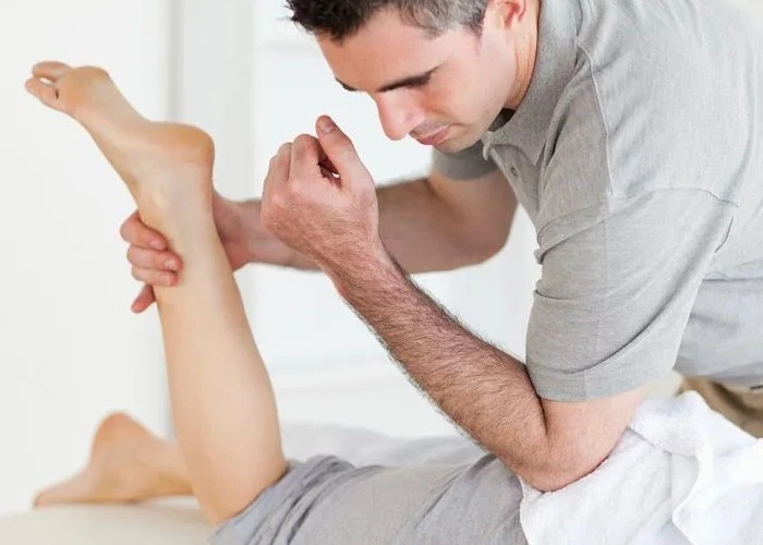Therapist performing leg and foot therapy for numbness relief