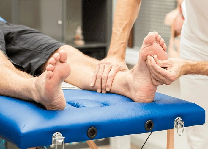 Chiropractor assessing foot sensation and mobility for numbness