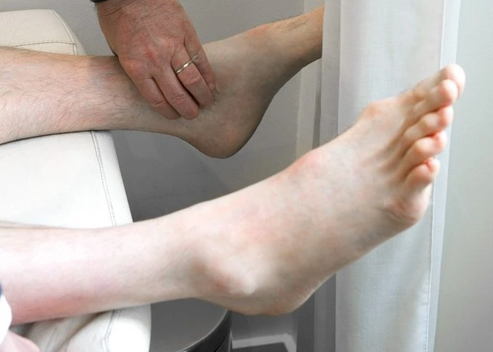 Doctor checking foot and ankle for signs of numbness or circulation issues